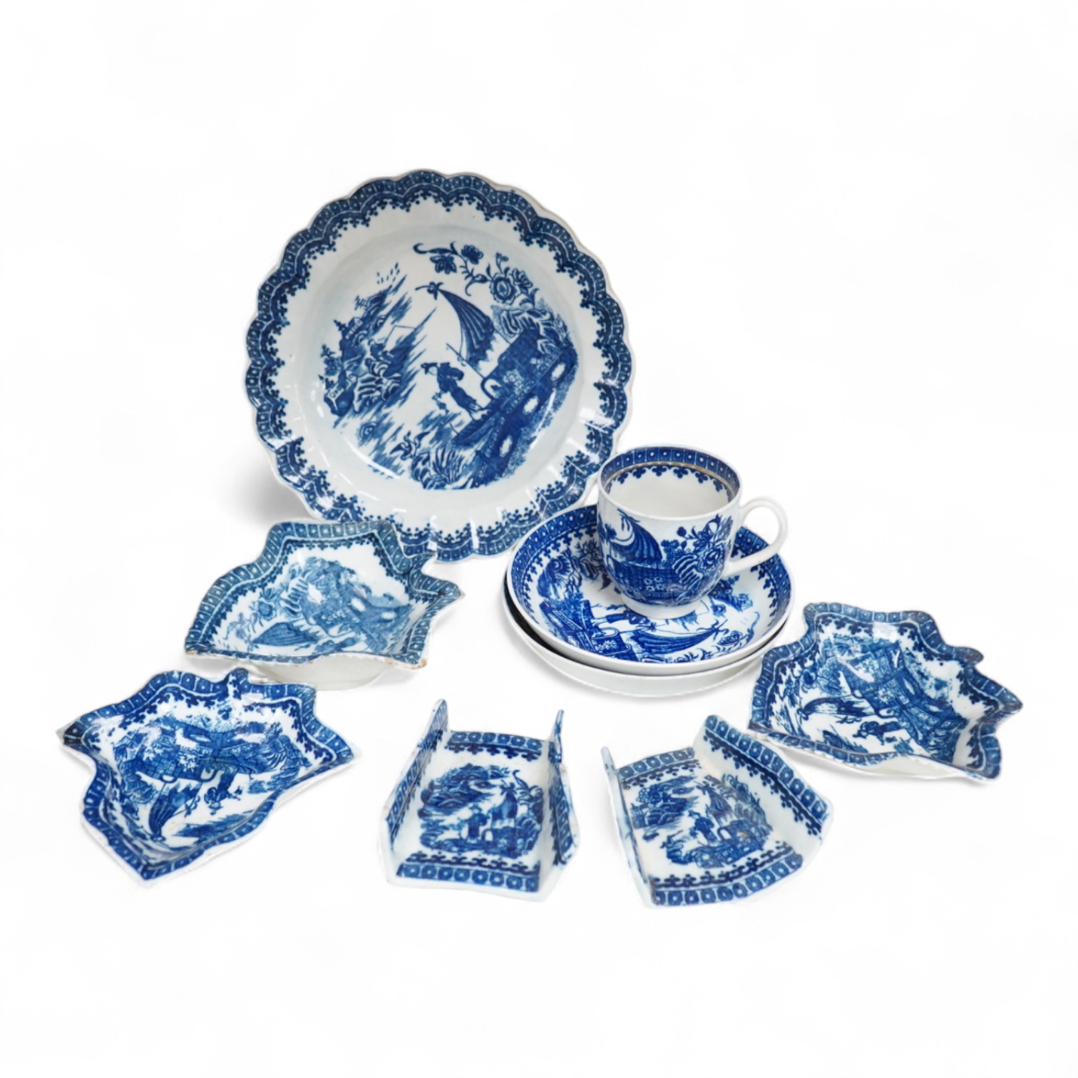 A group of 18th century Worcester or Caughley blue and white ‘Fisherman and Cormorant’ pattern wares; two asparagus dishes, three leaf pickle dishes, a cup and two saucers and a large dish- 18cm diameter (9).